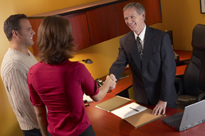Couple shaking hands with an attorney