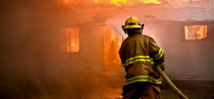 Fireman hosing down house fire
